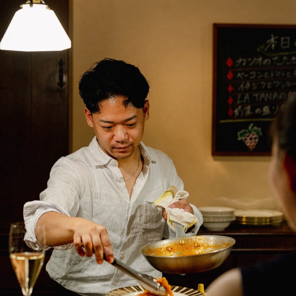 LA TANA 店主がカウンターで料理を盛り付けている様子